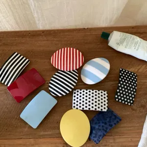 Detailansicht süßer geometrischer Haarklammern mit bunten Streifen und Polka-Dot-Mustern.
