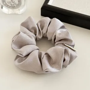 Crèmekleurige zijden satin haarscrunchie, zacht en elegant haaraccessoire voor dagelijks gebruik.