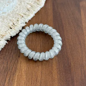 Transparent spiral hair tie detail view, elastic coiled cord for stylish ponytail styling.