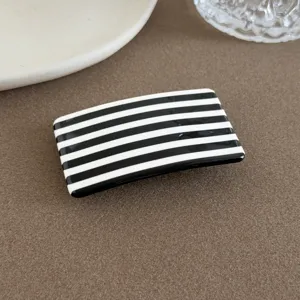 Nahaufnahme Detail der schicken schwarz-weißen Haarspange mit klaren geometrischen Linien.