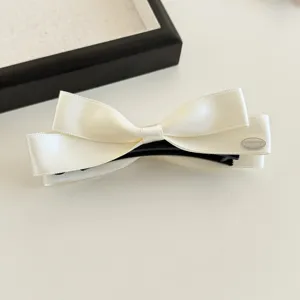 Exquisites Satin Schleife Haarklammer Detailbild, elegante cremeweiße Bananenklammer für Damen.