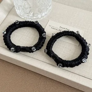 Black satin pleated crystal scrunchies detail view, elegant hair tie accessory for women.