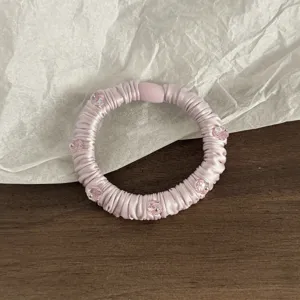 Rosa Satin Haargummi mit Kristallperlen, elegante Detailansicht für modische Pferdeschwänze.
