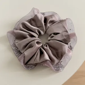 Close-up detail of a Korean style satin and mesh hair scrunchie with sparkling glitter edges.