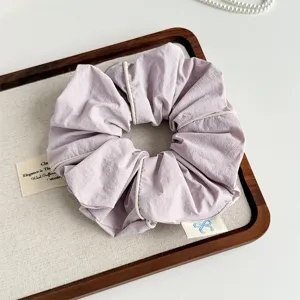 Close-up detail of Korean style minimalist piping design fabric hair scrunchie in light purple.