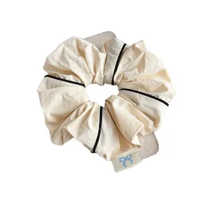 Korean minimalist fabric scrunchie with chic black piping and cute bow embroidery.