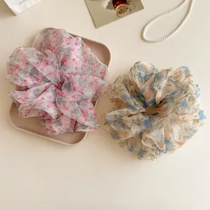 Large organza floral hair scrunchie detail view, showing soft fabric texture and flower pattern.