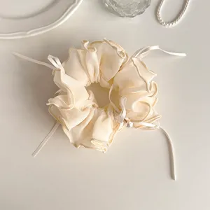 Chiffon hair scrunchie with cute ruffles, ribbon bows and pearl detail for women styling.