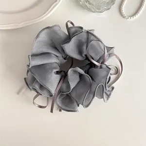 Detailed close-up of grey organza hair scrunchie featuring elegant fabric ribbon ties.