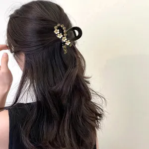 Pince à cheveux noire fleur de strass élégant accessoire coiffure demi-queue vue en détail