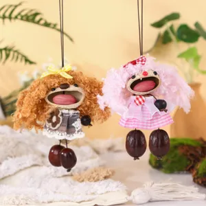 Detailed shot of handmade Indonesian nut shell doll pendant with fluffy hair and dress.