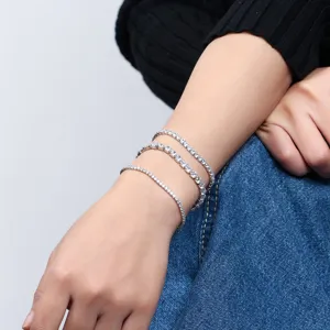 Primo piano dettagliato di bracciali tennis impilati in argento S925 con zirconi scintillanti.