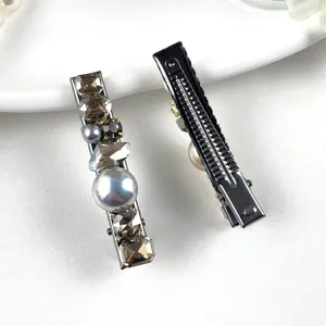 Detailed view of elegant rhinestone pearl hair clips, showing sparkling crystal and sturdy metal back.