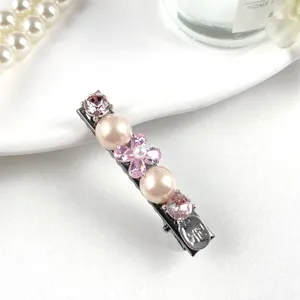 Detailed shot of sparkling rhinestone and pearl hair clip, elegant side barrette for women.