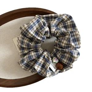 Chouchou en tissu a carreaux vintage elegant accessoire de coiffure femme style quotidien.