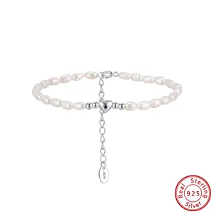 Primer plano de pulsera de perlas con colgante de corazón de plata 925 y cadena extensible.