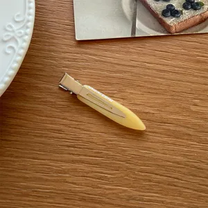 Minimalistische gelbe Entenschnabel Haarklammer Detailaufnahme, elegantes Accessoire.