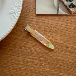 Nahaufnahme Detail der farbigen Acryl Entenschnabel Haarklammer mit Metall auf Tisch.