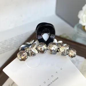 Small black hair claw clip with sparkling crystal rhinestones and cute butterfly details for styling.