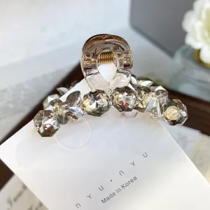 Small acrylic hair claw clip with crystal rhinestones for bangs and side hair styling.
