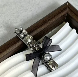 Elegant bow hair clip with sparkling rhinestones and pearls for a chic and stylish look.
