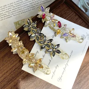 Detailed view of elegant crystal butterfly hair clips, sparkling rhinestones on PC banana clips.