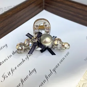 Small crystal pearl hair claw clip with black bow for women hair styling and daily wear.