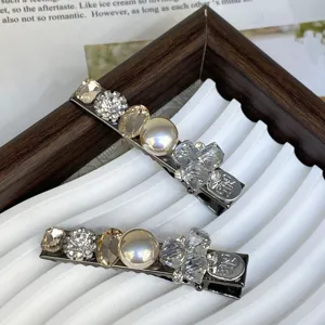 Close-up detail view of elegant silver hair clips decorated with pearls, rhinestones, and crystals.