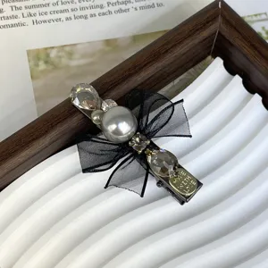 Exquisite black mesh bow hair clip detail featuring large pearl and sparkling crystal rhinestones.