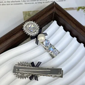 Detailed view of silver hair clip featuring sparkling crystals, faux pearl, and black bow.