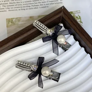 Elegant black bow hair clips with pearls and sparkling rhinestones for women hair styling.