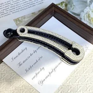 Close-up detail shot of the luxury rhinestone paperclip design banana hair clip in black and gold.