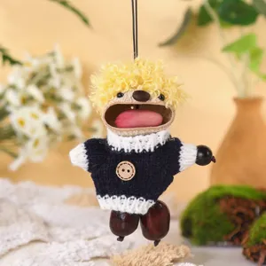 Close-up of creative seed pod hanging ornament with cute knitted sweater and yellow hair.
