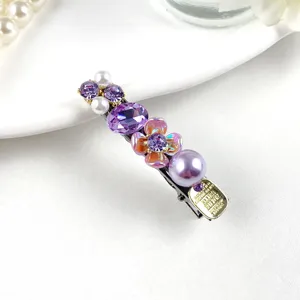 Close-up detail of luxury purple crystal and pearl hair clip, showing exquisite craftsmanship.