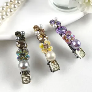 Exquisite crystal rhinestone and pearl duckbill hair clip detail, shimmering elegant side hair accessory.