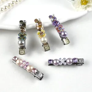 Close up of luxury rhinestone and pearl hair clips detail showing sparkling crystals and metal duckbill.