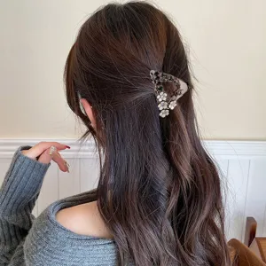 Detailed view of the rhinestone camellia hair claw clip worn on half-up hairstyle.