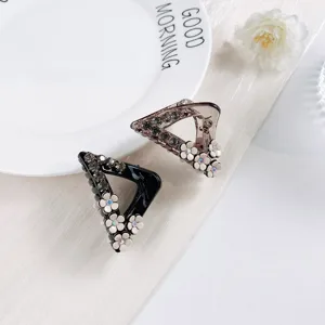 Details of the elegant rhinestone and floral hair claw clip, chic geometric design.