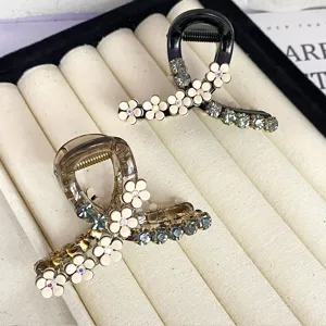 Close-up detail of rhinestone camellia hair claw, elegant black and brown acetate hair accessory.