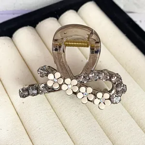 Elegant camellia rhinestone hair claw clip for women, sparkling crystal mini shark clip accessory.