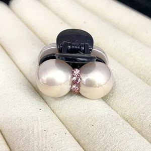 Pearl hair claw clip for women, mini black plastic shark clip with pink rhinestone detail.
