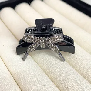 Black rhinestone hair claw clip detail, exquisite crystal bow design for elegant hair.