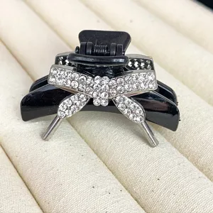 Black rhinestone bow hair claw clip, elegant sparkling crystal hair accessory for women.