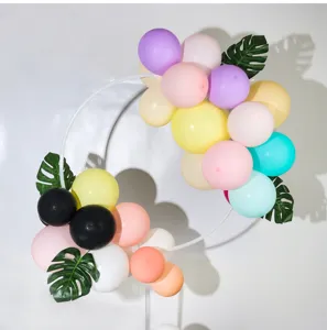 Close-up of balloon ring stand with colorful balloons and artificial leaves for party.