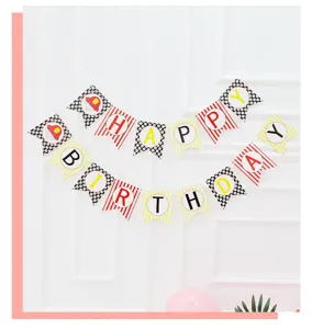 Close up detail view of children birthday party paper banner hanging on white wall background.