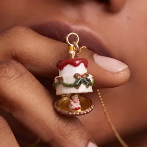 Détail en gros plan du collier médaillon gâteau de Noël avec émail délicat et jolie figurine.