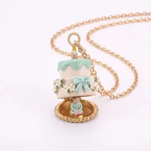 Détail de collier pendentif médaillon gâteau, charme nœud fleur émail mignon, chaîne or.