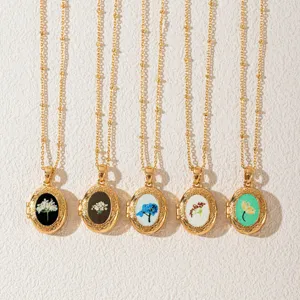 Vintage gold oval locket necklace set featuring delicate pressed dried floral designs.
