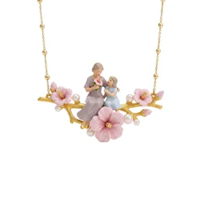 Elegant gold-toned necklace featuring mother and child figures on a floral branch pendant.