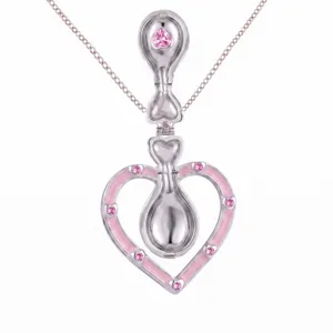 Gros plan détaillé du collier pendentif cœur en argent avec oxydes de zirconium roses et féerique.